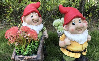 公園草坪上兩個(gè)玻璃鋼彩繪卡通背竹筐和推花盆小推車的小矮人雕塑