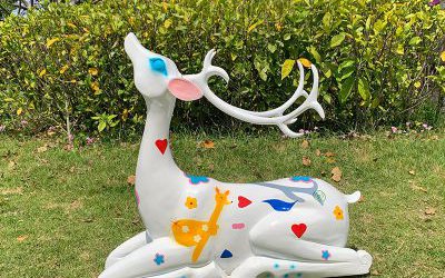 草坪上臥著的玻璃鋼彩色公鹿梅花鹿雕塑