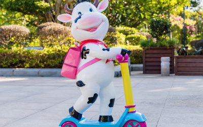 幼兒園一只騎車背包的玻璃鋼卡通牛雕塑