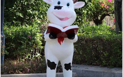 校園擺放一只看書(shū)的玻璃鋼卡通奶牛雕塑